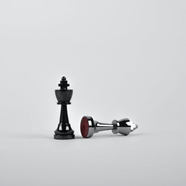 two silver chess pieces on white surface