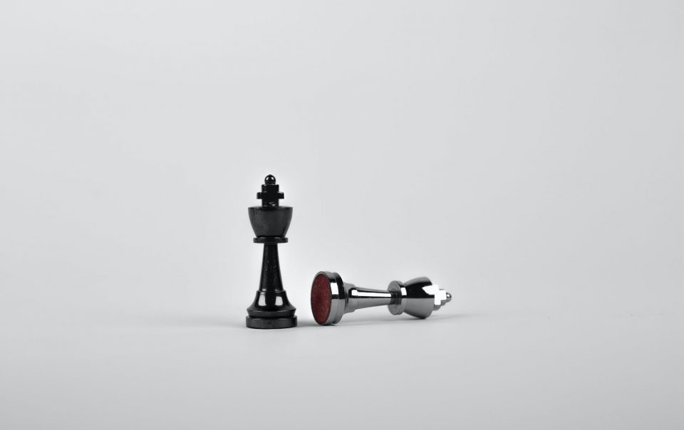 two silver chess pieces on white surface