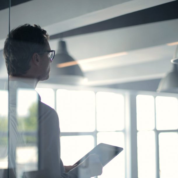 formal man with tablet giving presentation in office